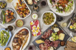 olives, eggs, meats, cheeses and spreads out on a table in potluck style