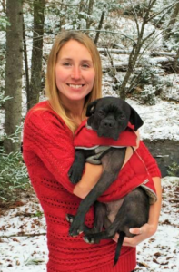 Lauren holding her dog with a snowy background